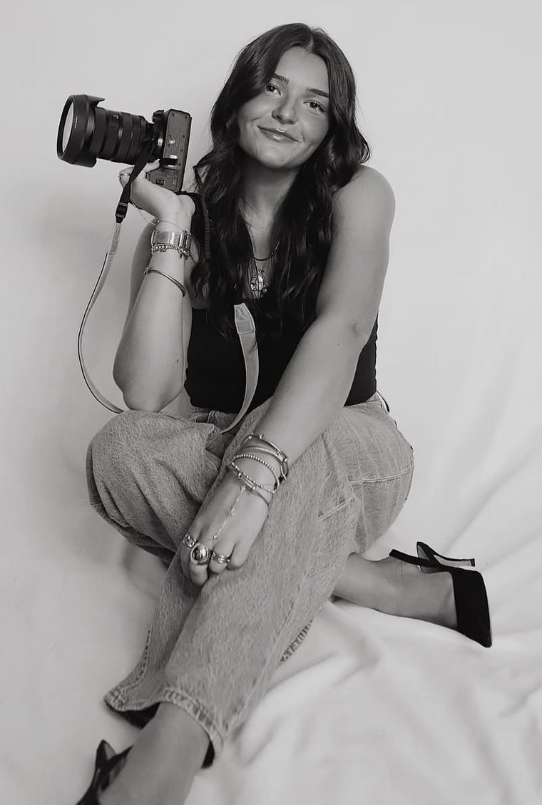 Hayden sitting in a studio holding her camera